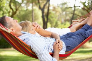 Older couple relaxing in a hammock enjoying retirement.