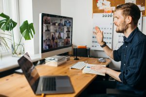 Young man having Zoom video call via a computer in the home office during Coronavirus.